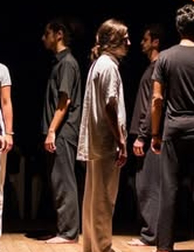 Alunos em fila no palco, em exercício de presença cênica